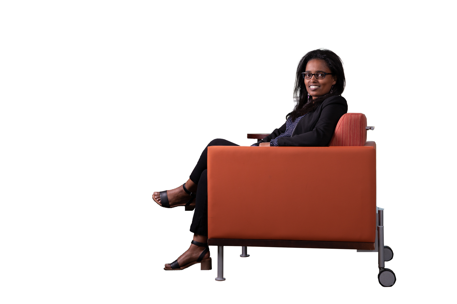 International student at UM sits in chair and smiles at camera