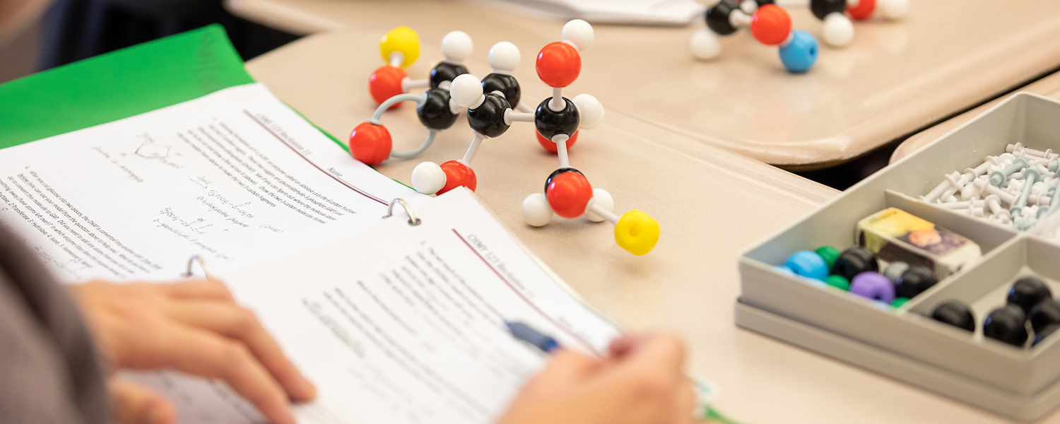 A student takes notes during a UM chemistry class.