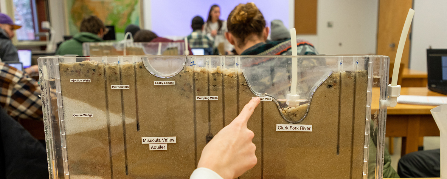 Students work in a science lab with tabletop models that represent the Clark Fork River.