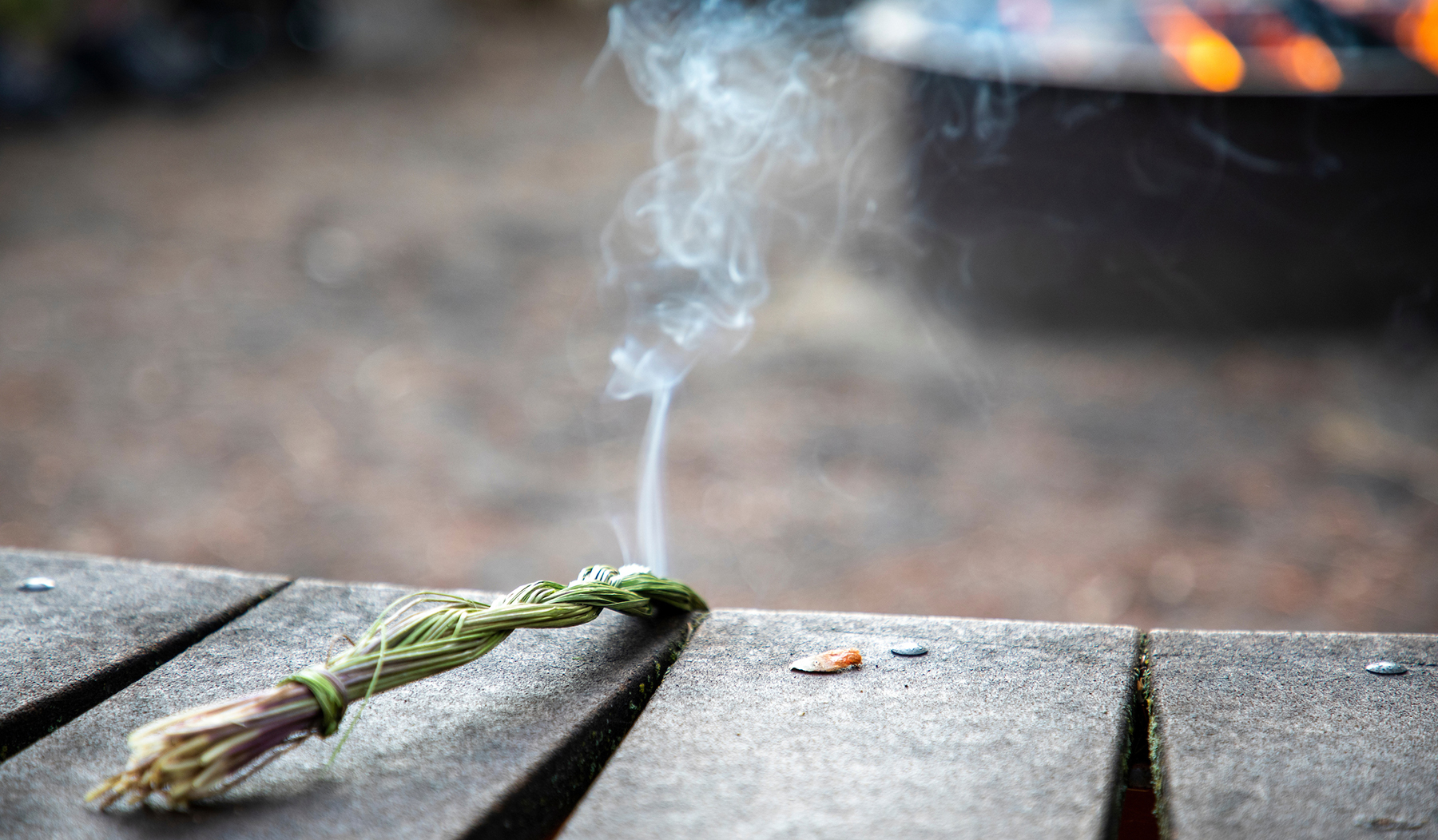 A sage bushel burns during a ceremony outside the Payne Family Native American Center at UM.